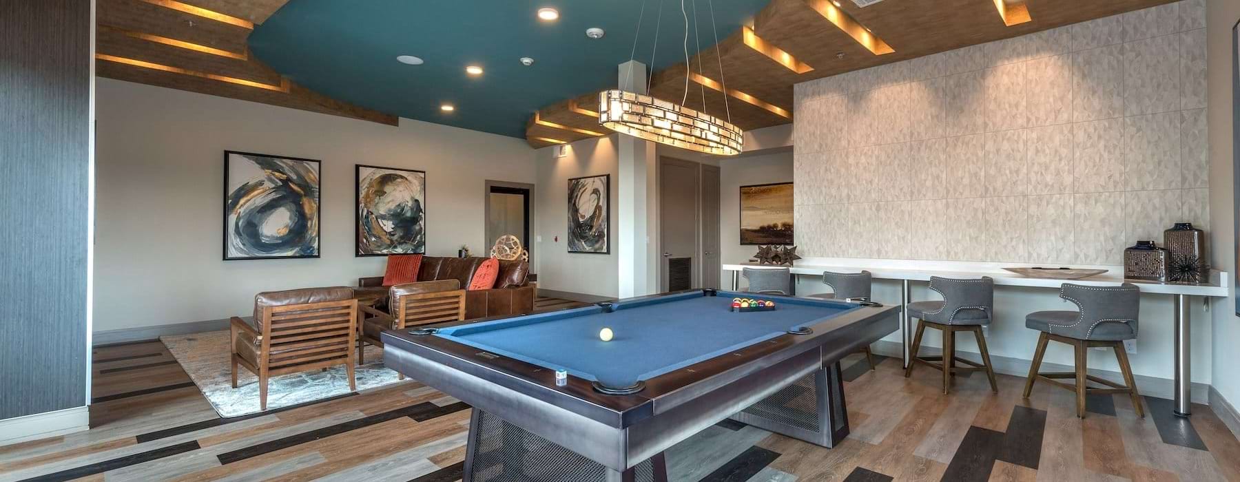 a clubroom with a pool table and chairs